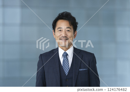 A businessman in his late 50s smiling at the camera 124176482