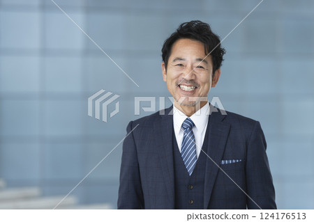 A businessman in his late 50s smiling and looking at the camera A businessman in his late 50s smiling and looking at the camera 124176513