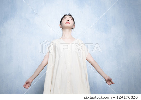 一位美麗的年輕女子伸出雙手深吸一口氣 — — 這是一幅無壓力的畫面 124176826