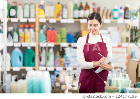 saleswoman writes down on paper the amount of the remaining goods in the warehouse saleswoman writes down on paper the amount of the remaining goods in the warehouse 124177189