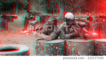 Two paintball player in camouflage and mask aiming with gun in shootout 124177240