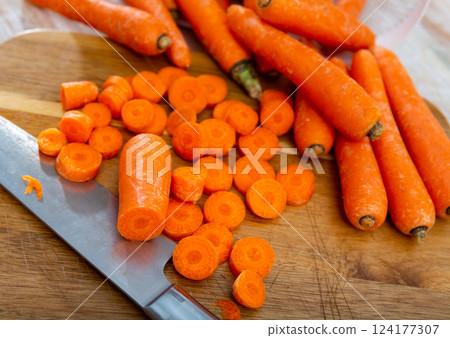 Pile of fresh sweet carrots on wooden cutting board 124177307
