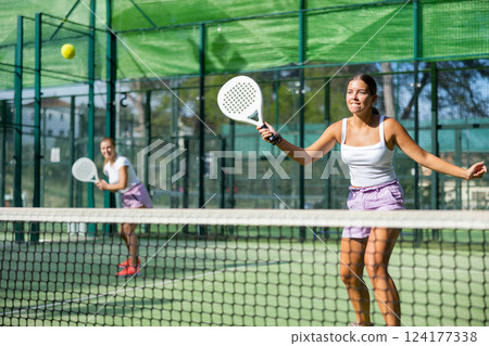 Girl playing padel tennis match during training on court 124177338