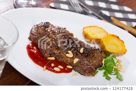 Well done roasted beef steak with ketchup and pine nuts Well done roasted beef steak with ketchup and pine nuts 124177428