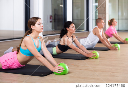 Adults and sports people perform a stretching exercise 124177468