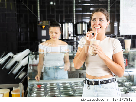 Smiling young girl enjoying refreshing bubble tea 124177812