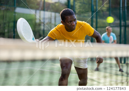 Man playing padel tennis on court Man playing padel tennis on court 124177843