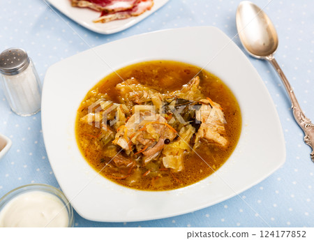 Shchi, cabbage soup cooked on mushroom broth with pork and sour cream 124177852