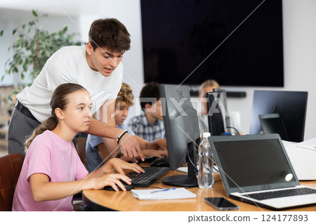 Guy teacher teaches girl student how to use computer Guy teacher teaches girl student how to use computer 124177893