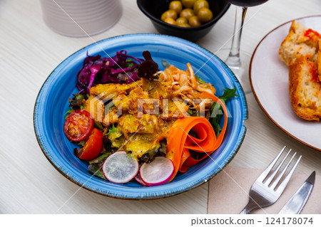 Breaded chicken fillets with mustard vinaigrette and vegetables Breaded chicken fillets with mustard vinaigrette and vegetables 124178074