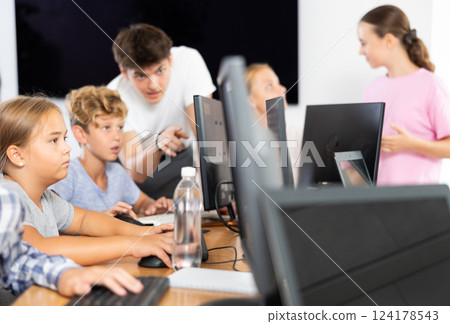 Preteen girl working with computer programs in training room 124178543