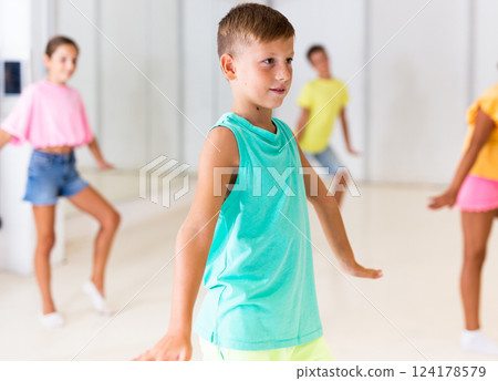 Concentrated tween boy learning charleston during group dance class 124178579
