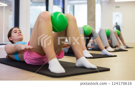 Young woman doing exercises with pilates ball Young woman doing exercises with pilates ball 124178616