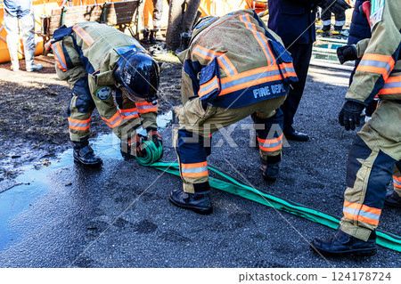 Firefighters demonstrate firefighting techniques at the New Year's parade and put away fire hoses 124178724