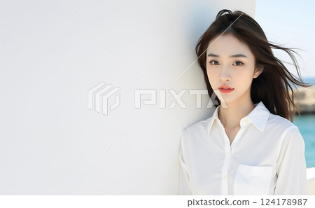 站在白牆前的年輕女子 124178987