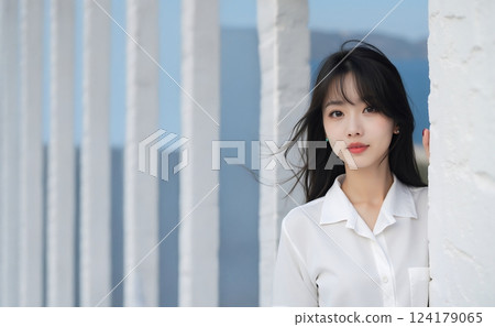 Young woman standing in front of a white wall 124179065