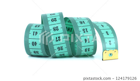 A light green measuring tape curled on a white background, a common tool for sewing projects. 124179126
