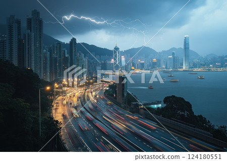 High angle view of lightning over a cityscape with flowing traffic at night. High angle view of lightning over a cityscape with flowing traffic at night. 124180551