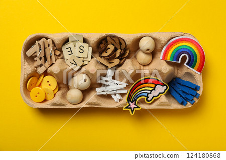 Art supplies in egg tray on yellow background, top view 124180868