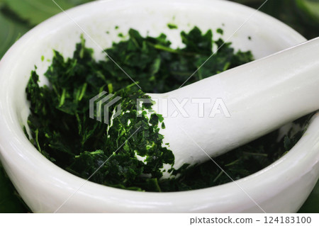Medicinal neem leaves crushing in a mortar 124183100