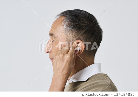 穿著休閒服的老人使用無線耳機 穿著休閒服的老人使用無線耳機 124184885