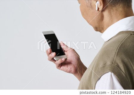 一位穿著休閒服的老人用智慧型手機的後視圖 124184920