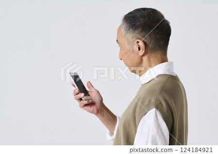 一位穿著休閒服的老人用智慧型手機的後視圖 一位穿著休閒服的老人用智慧型手機的後視圖 124184921