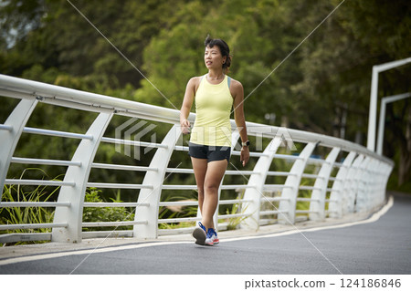 young asian woman jogger walking outdoors young asian woman jogger walking outdoors 124186846