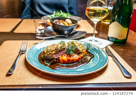 delicious romantic Gala dinner table setting with bottle glass of wine, laid table, side view food porn 124187274