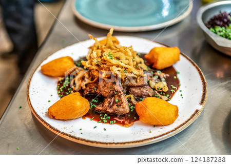Fried mini potatoes with rosmarine and liver meat on a white plate 124187288