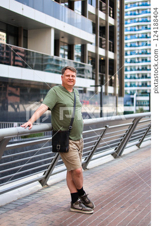 A blond man with a dense build in summer clothes on a city street 124188404