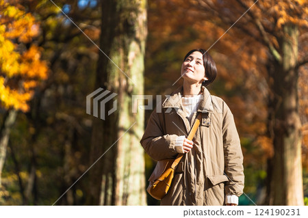 Woman enjoying autumn leaves lifestyle image 124190231