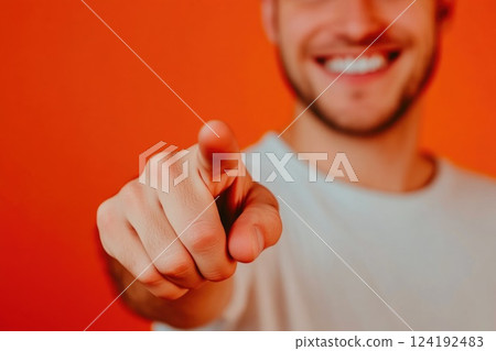 Man smiling and gesturing with his finger on orange background 124192483