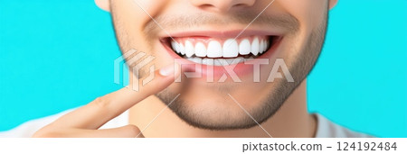 Man pointing at white smile close-up, studio background 124192484