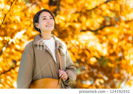 Woman enjoying autumn leaves lifestyle image Woman enjoying autumn leaves lifestyle image 124192932