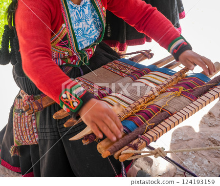 Andean artisan weaving a colorful textile near Cusco, Peru 124193159