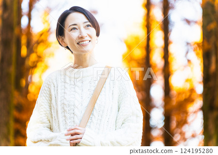A woman strolling through a forest of autumn leaves Lifestyle image 124195280