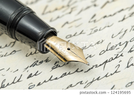 Close-up of an elegant fountain pen resting on vintage handwritten letters.. 124195695