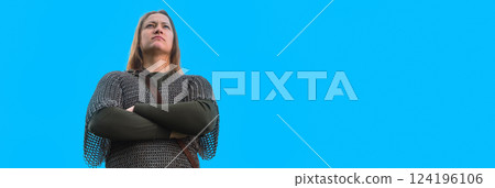 War calling concept. Beautiful woman in medieval chain mail. A woman viking on blue background. 124196106