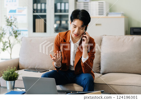 Male businessman talk mobile phones and working on laptop computers, online business, work from home, teleworking concept. Male businessman talk mobile phones and working on laptop computers, online business, work from home, teleworking concept. 124196301