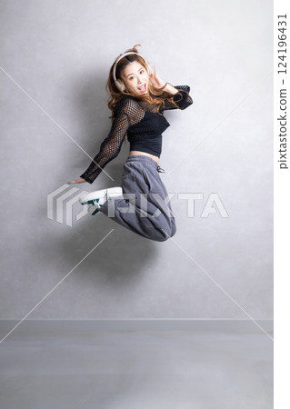 Woman jumping while listening to music 124196431