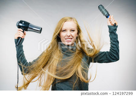 Girl holds hair accessories, styling hair 124197299