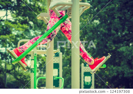 Girl doing legs exercises in outdoor gym 124197308