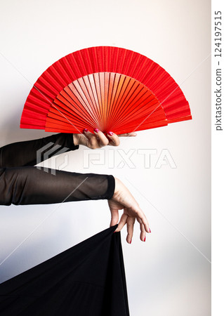 Elegant display of red asian fan in female hands with black dress and sheer sleeves Elegant display of red asian fan in female hands with black dress and sheer sleeves 124197515