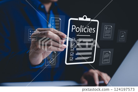 Policy documentation and compliance concept. A person reviews digital document labeled "Policies" with icons, checklists, certifications, and financial detail. policy management, regulatory compliance Policy documentation and compliance concept. A person reviews digital document labeled "Policies" with icons, checklists, certifications, and financial detail. policy management, regulatory compliance 124197573