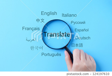 Translation and Multilingual Communication Concept. A magnifying glass highlights the word "Translate," surrounded by names of multiple languages, multilingual translation, and global communication. 124197610