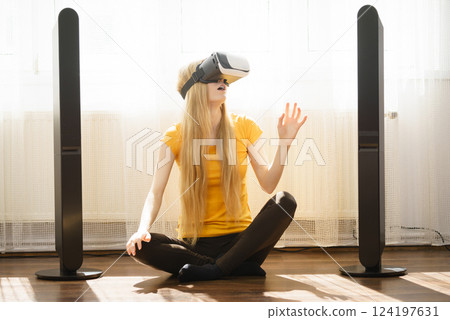 Girl wearing virtual reality goggles at home Girl wearing virtual reality goggles at home 124197631