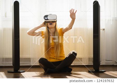 Girl wearing virtual reality goggles at home Girl wearing virtual reality goggles at home 124197632