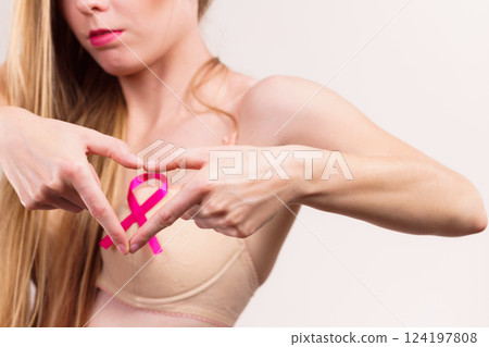 Woman with pink cancer ribbon on breast 124197808