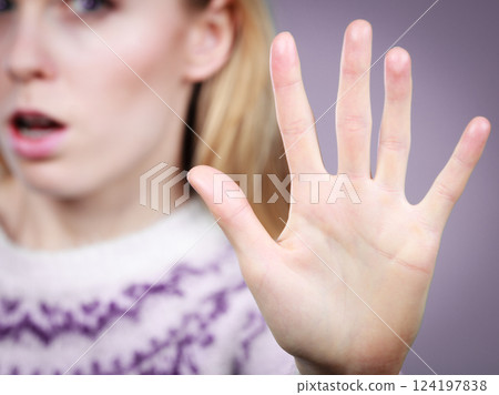 Woman making stop gesture with open hand 124197838